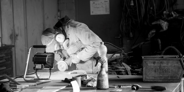 Mann mit Schutzutensilien am Arbeiten Mann mit Schutzutensilien am Arbeiten