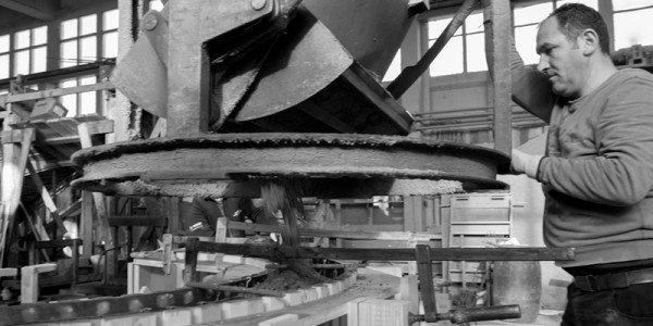 Mann mit Betonkübel in Produktionshalle Mann mit Betonkübel in Produktionshalle
